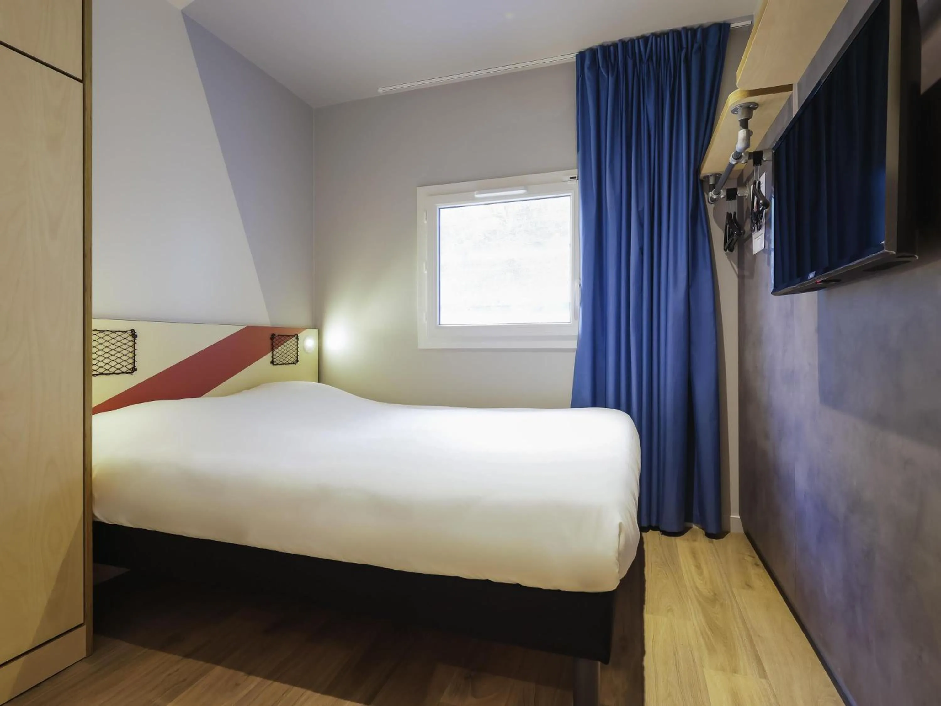 Room with One Queen Bed and an armoire bed in ibis Budget Villemomble